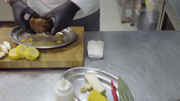 Successful Chef Pouring Raw Piece of Meat with Soy Sauce Before Baking in the Oven in the Restaurant