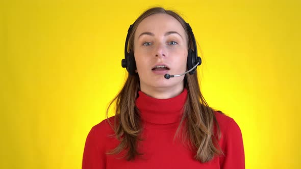 Successful Woman in Headset Gesturing and Talking on Camera on a Yellow Background