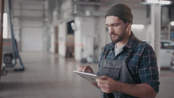 Auto Mechanic Using Tablet in Workshop