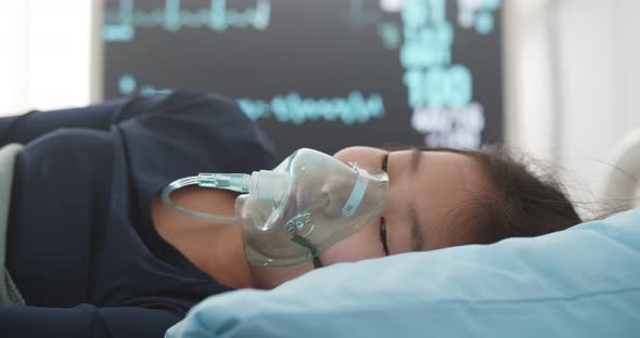 Asian Girl Suffering From Pneumonia Lying in Hospital Bed with Oxygen Mask