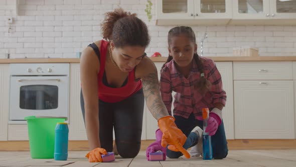 Mom and Girl Wiping Floor with Cleaning Supplies