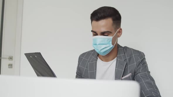 Male Student in Medical Mask Working with Laptop at Table During Remote Studying