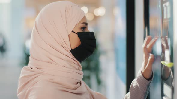 Young Arabic Woman in Protective Medical Mask Stands Near Selfservice Machine Muslim Girl Shopping