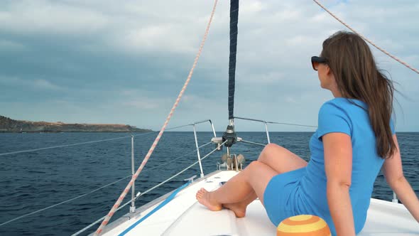 Woman in a Yellow Hat and Blue Dress Girl Rests Aboard a Yacht Near the Lighthouse on Summer Season