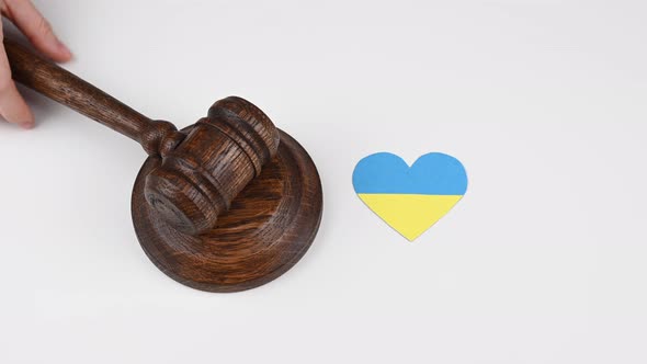 The Judge Beats the Gavel Next to the Heart with the Flag of Ukraine