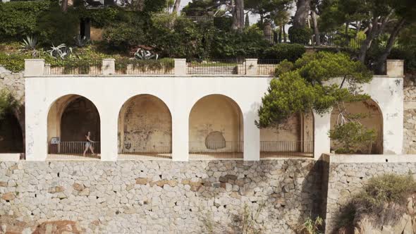 Classy girl walking through the passage of the hacienda in amazing Costa Brava beauties.