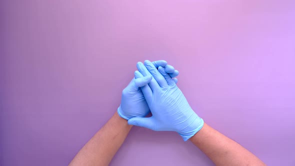 Doctor Hand with Medical Gloves Showing Support Sign on Purple Background