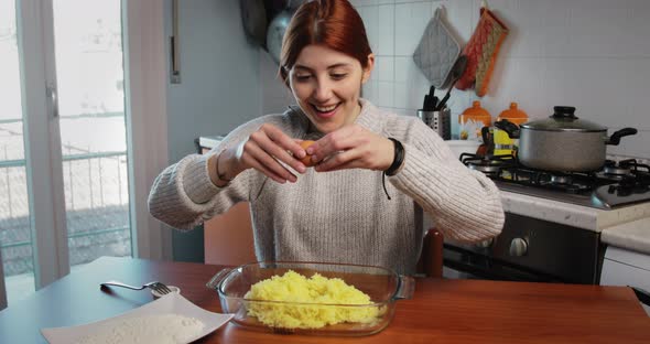 Girl Breaks the Egg to Put It in the Mashed Potatoes for Italian Gnocchi