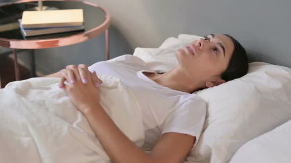 Pensive Latin Woman Laying Awake in Bed 