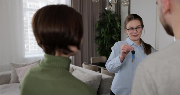 Portrait of Real Estate Agent Talking to Customers in New Apartment and Giving Home Keys