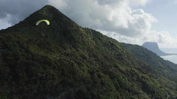 Aerial view of a person doing paragliding among the mountain, Mauritius.