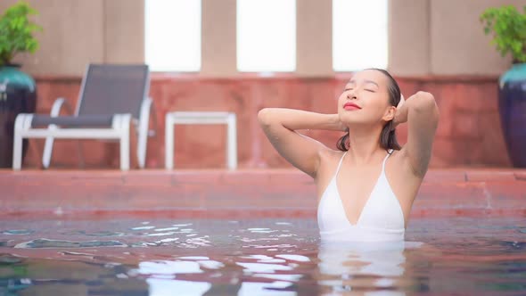 Young asian woman enjoy around outdoor swimming pool for leisure