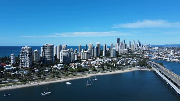 Aerial view of a coastal urban metropolitan sprawl with a towering high-rise skyline and city infras