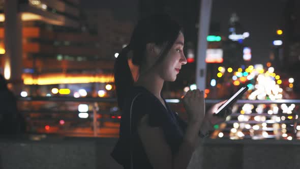 Woman Checking Phone Standing Over Bridge