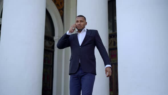 Handsome African American Businessman Walking Down Stairs Talking on the Phone