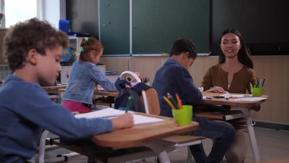 Teacher Talking To Mixed Race Boy in Class