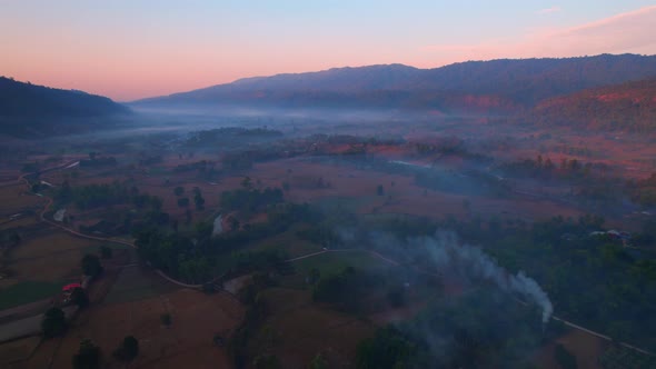 4K aerial view over mountain scenery rural Thailand at sunset