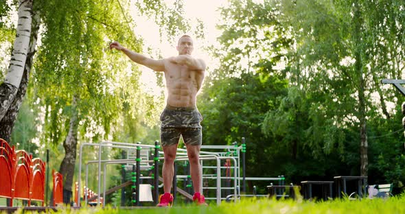 Handsome Young Sportsman Performing Warming Up Exercises During Workout at Sports Ground