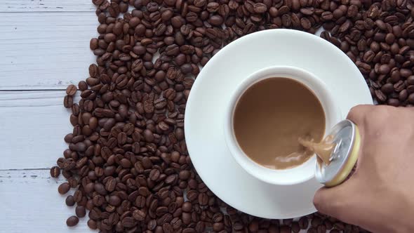 Pouring Can Coffee in a Cup on Table