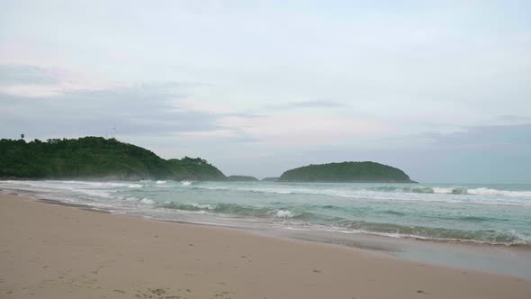 Ocean waves breaking into the shore on the beach in Phuket, Thailand.