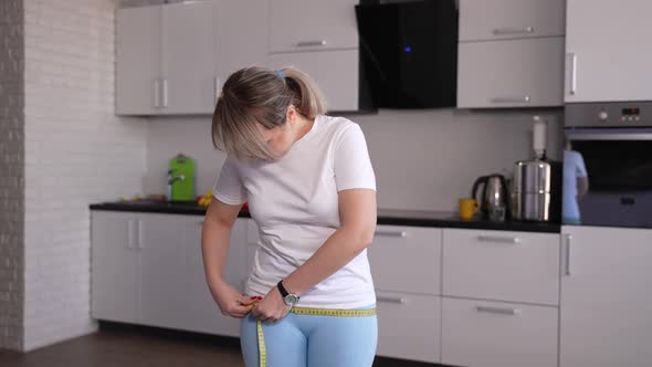 Losing Weight Woman Taking Measurements in Kitchen