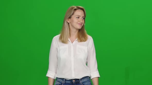 Portrait of Blonde Woman Is Calmly Walking and Smiling on Green Screen. Chroma Key. Front View. Slow