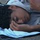 Freezing African-American refugee lying on street in sleeping bag - VideoHive Item for Sale