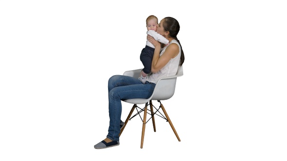 Mother and cute baby sitting on a chair on white background.