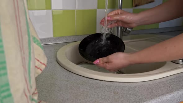 Girl's Hands are Washing Plate with Washcloth and Detergent in Full Sink Slowmo