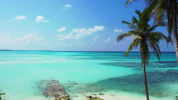 Tropical fly over copy space shot of a paradise sunny white sand beach and blue ocean background