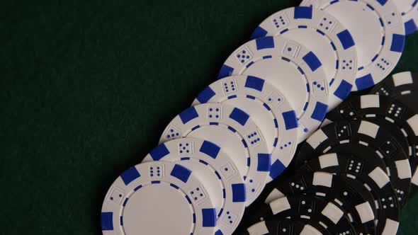 Rotating shot of poker cards and poker chips on a green felt surface - POKER 060