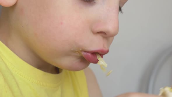 Portrait of a Caucasian boy, 6-7 years old, eating shawarma lavash.