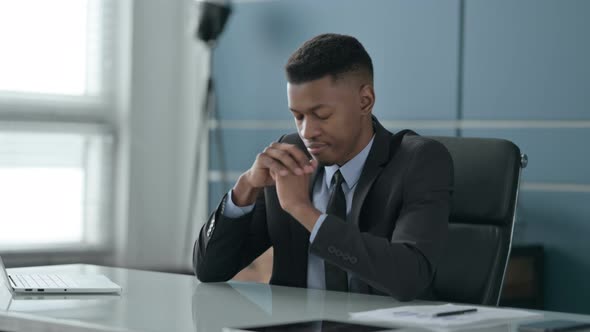 Sleepy African Businessman Taking Nap While Sitting in Office