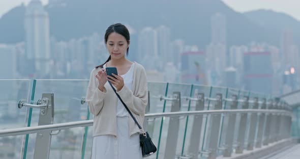 Woman look at mobile phone in Hong Kong city