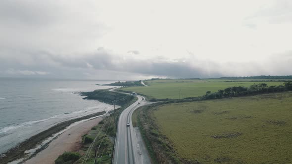 Drone following a road where cars are passing off the coast of Paia, on the island of Maui, Hawaii.