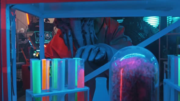 An Alien with Tentacles in the Lower Face Looking Around in the Secret Lab and Touching the Flasks alt