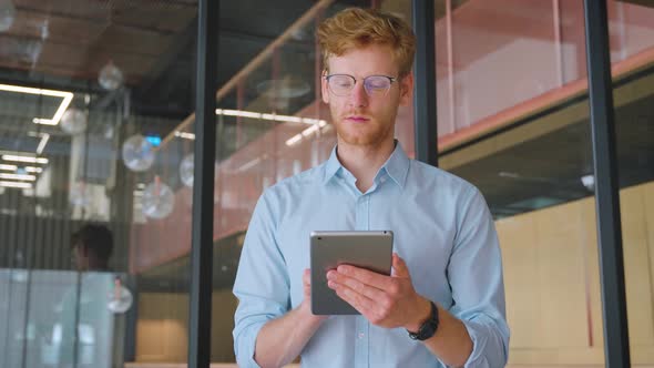 Middle Aged Businessman Use Tablet Computer Apps for Work in Office