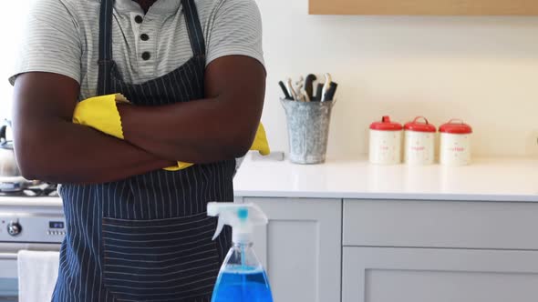 Confident man standing with arms crossed in kitchen