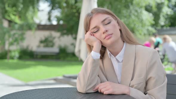 Sleeping Young Businesswoman Sitting in Outdoor Cafe