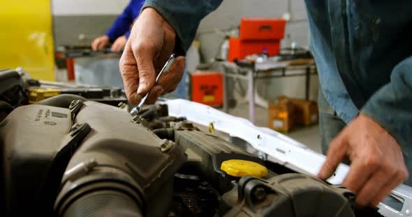 Mechanic repairing a car in garage 4k