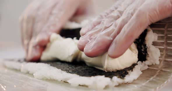 Restaurant Kitchen. Male Sushi Chef Prepares Japanese Sushi Rolls of Rice, Salmon, Avocado, Cheese