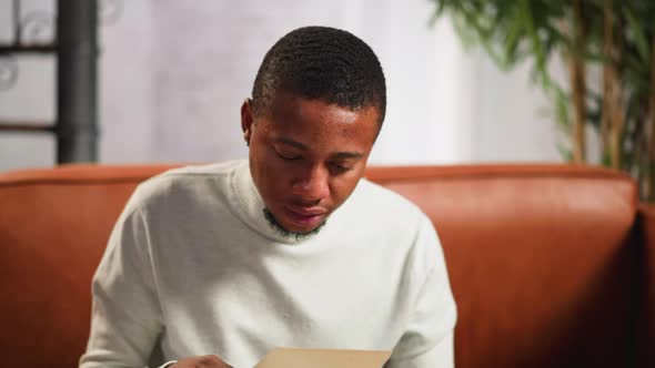 Black Guy Looks at Family Old Picture Closing Face By Hand