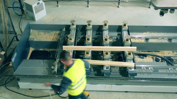 Technician Is Blowing Sawdust Away From the Equipment