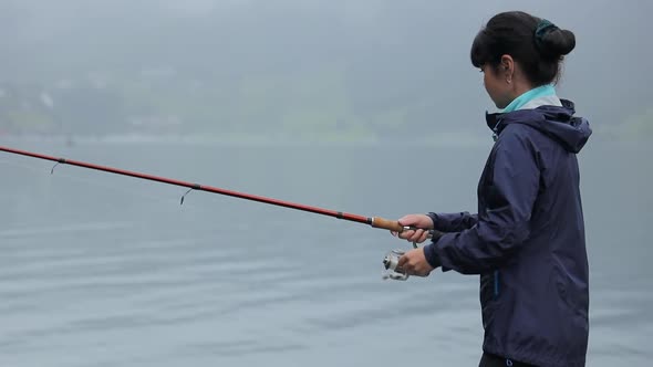 Woman Fishing on Fishing Rod Spinning in Norway