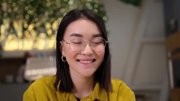 Portrait of Beautiful and Smiling Asian Girl Wearing Glasses Indoor