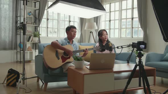 Asian Children Playing Guitar And Sing A Song While Streaming