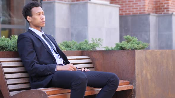 Serious African Businessman Leaving After Sitting on Bench