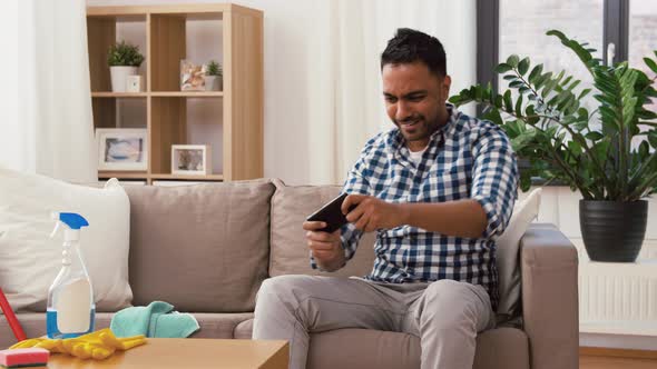 Man Playing Game on Smartphone After Cleaning Home 88