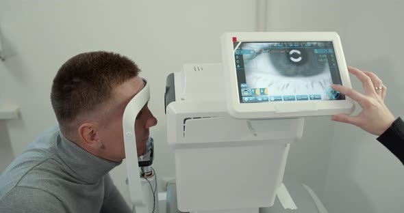 Young Man with a Short Haircut in the Office Checking Eyesight