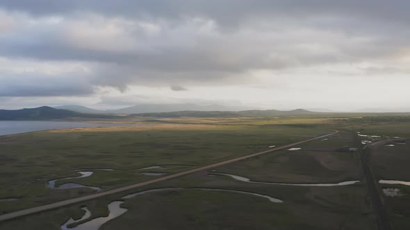 Drone View of a Sunset in a Valley with a River and Mountain Ranges